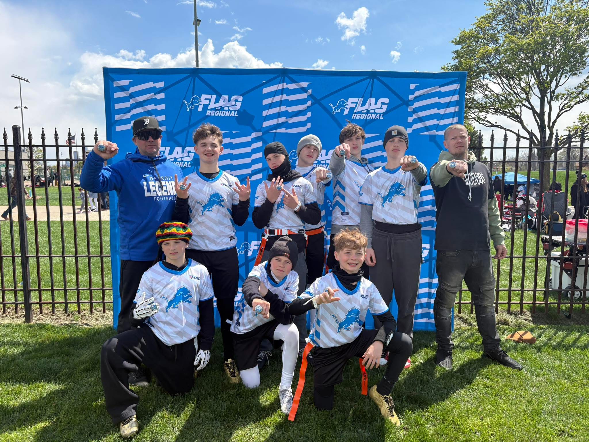 Detroit Legends players and coaches displaying rings at a flag football regional event